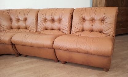 Divano modulare vintage in pelle cognac con cuscini capitonnè e design curvo in stile anni settanta