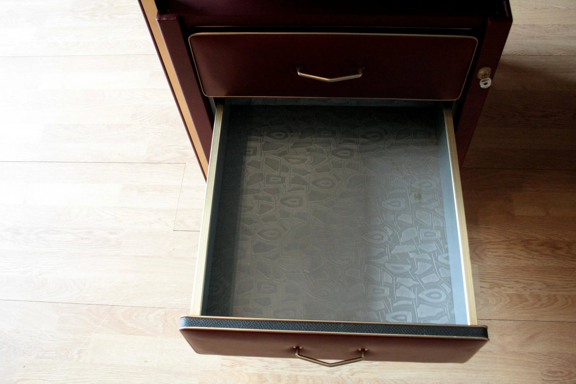 Cassetto aperto di scrivania ministeriale disegnata da umberto mascagni in similpelle bordeaux con ferramenta ottone