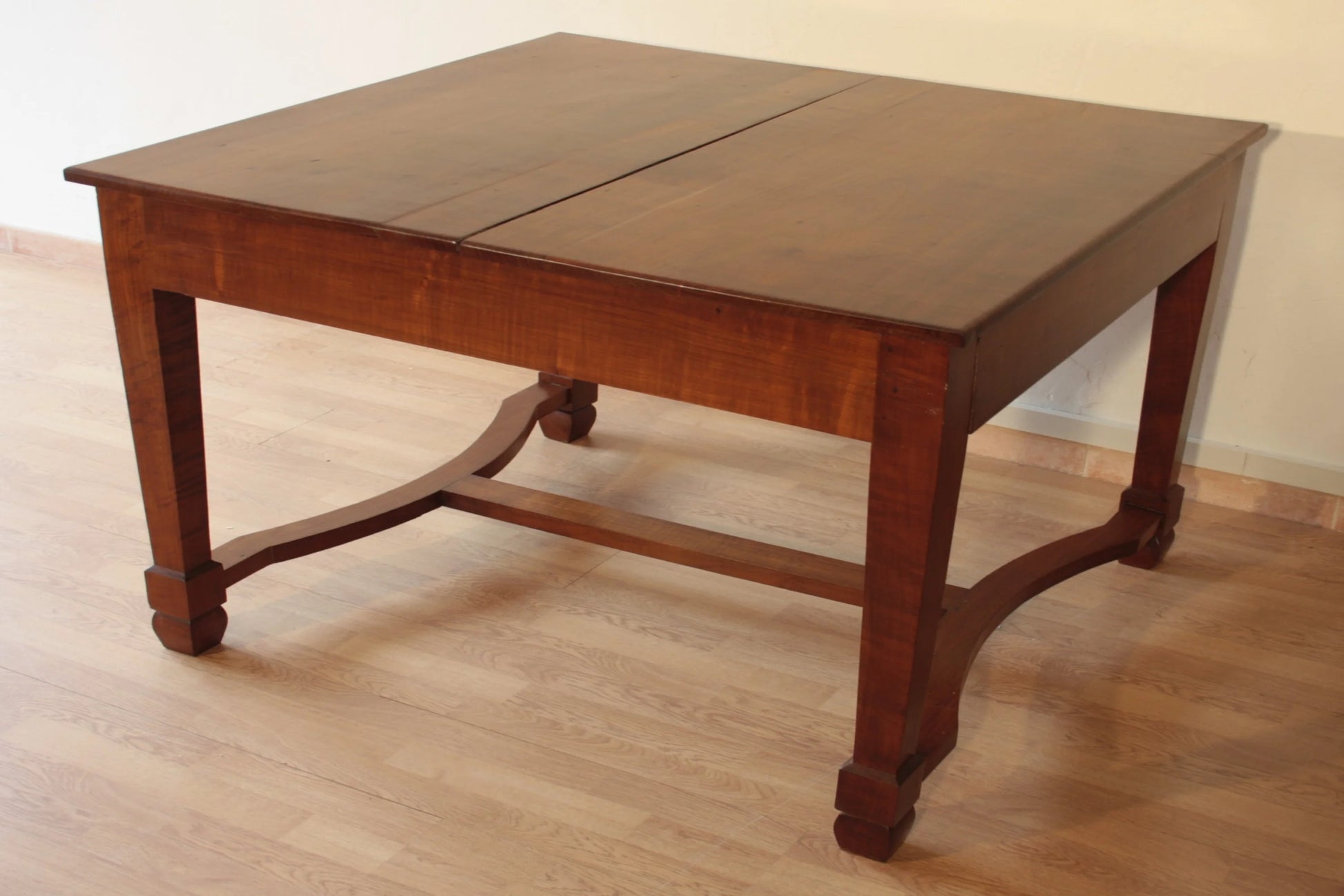 Antico ed elegante tavolo decò vintage in ciliegio massello con base a traversa e gambe dritte allungabile restaurato